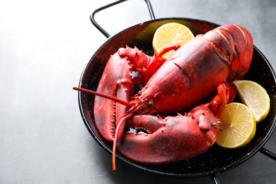 Photo of Delicious boiled lobster with lemon pieces on grey table, closeup