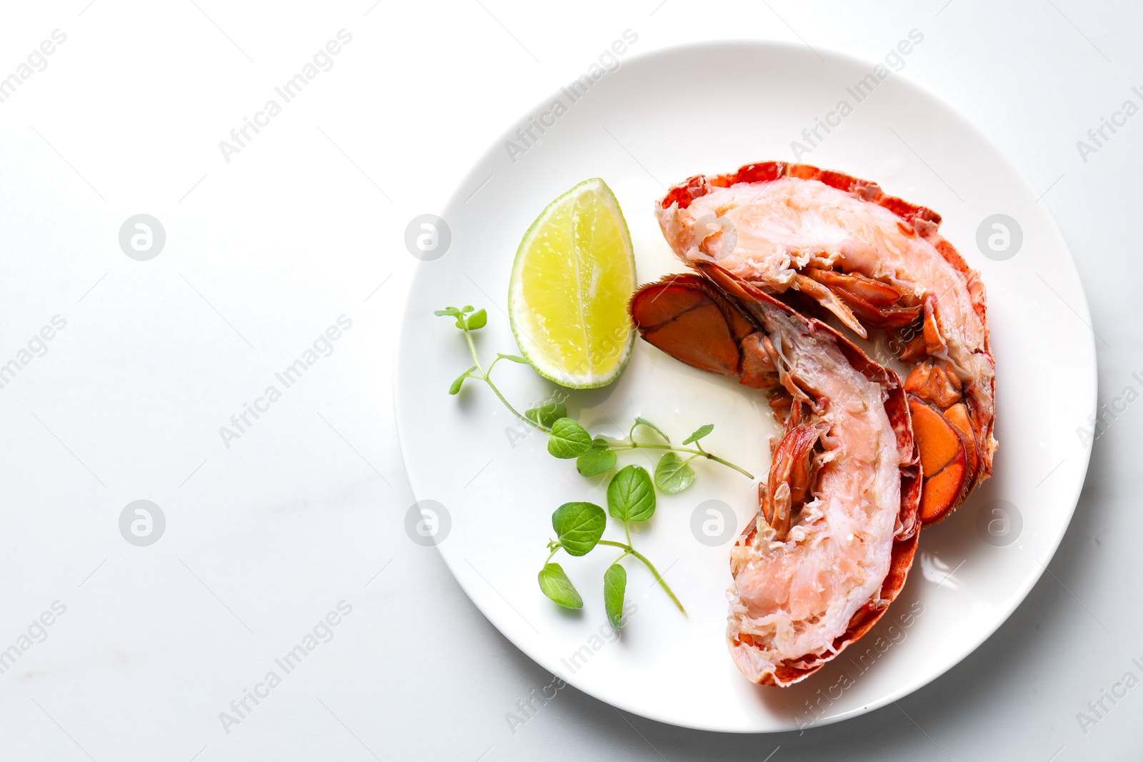 Photo of Delicious boiled lobster served on white table, top view. Space for text