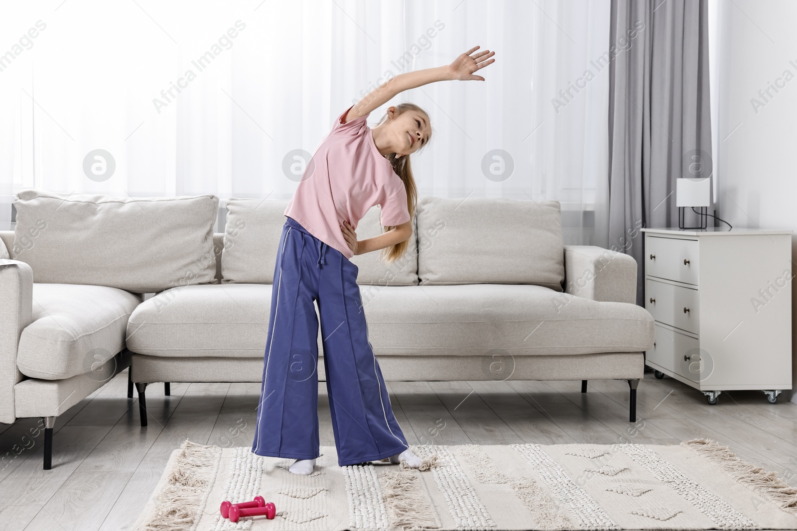 Photo of Little girl exercising at home. Morning routine