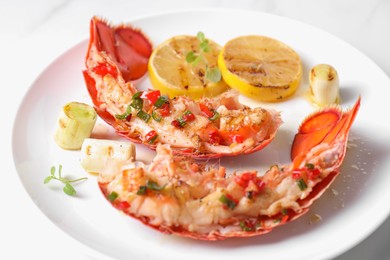 Photo of Delicious lobster tails with lemon, microgreens and green onion on white table, closeup