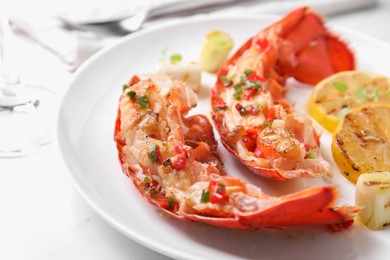 Photo of Delicious lobster tails with green onion on white table, closeup