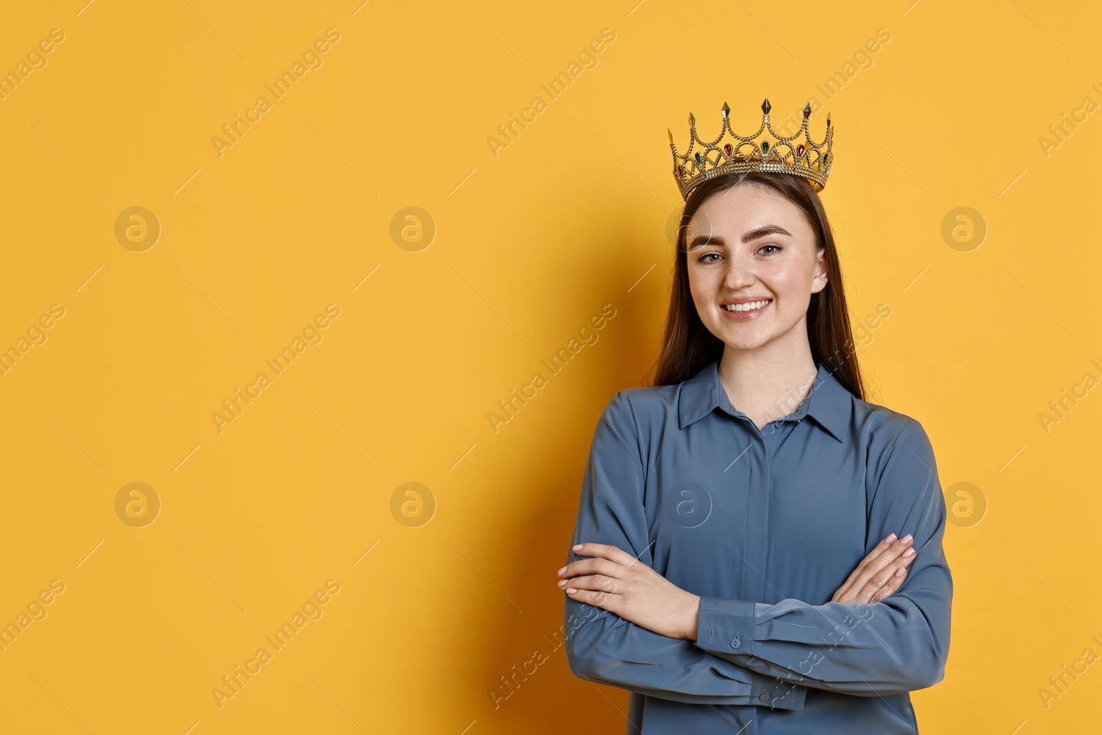 Photo of Happy woman in elegant crown on yellow background. Space for text