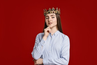 Photo of Woman in elegant crown on dark red background