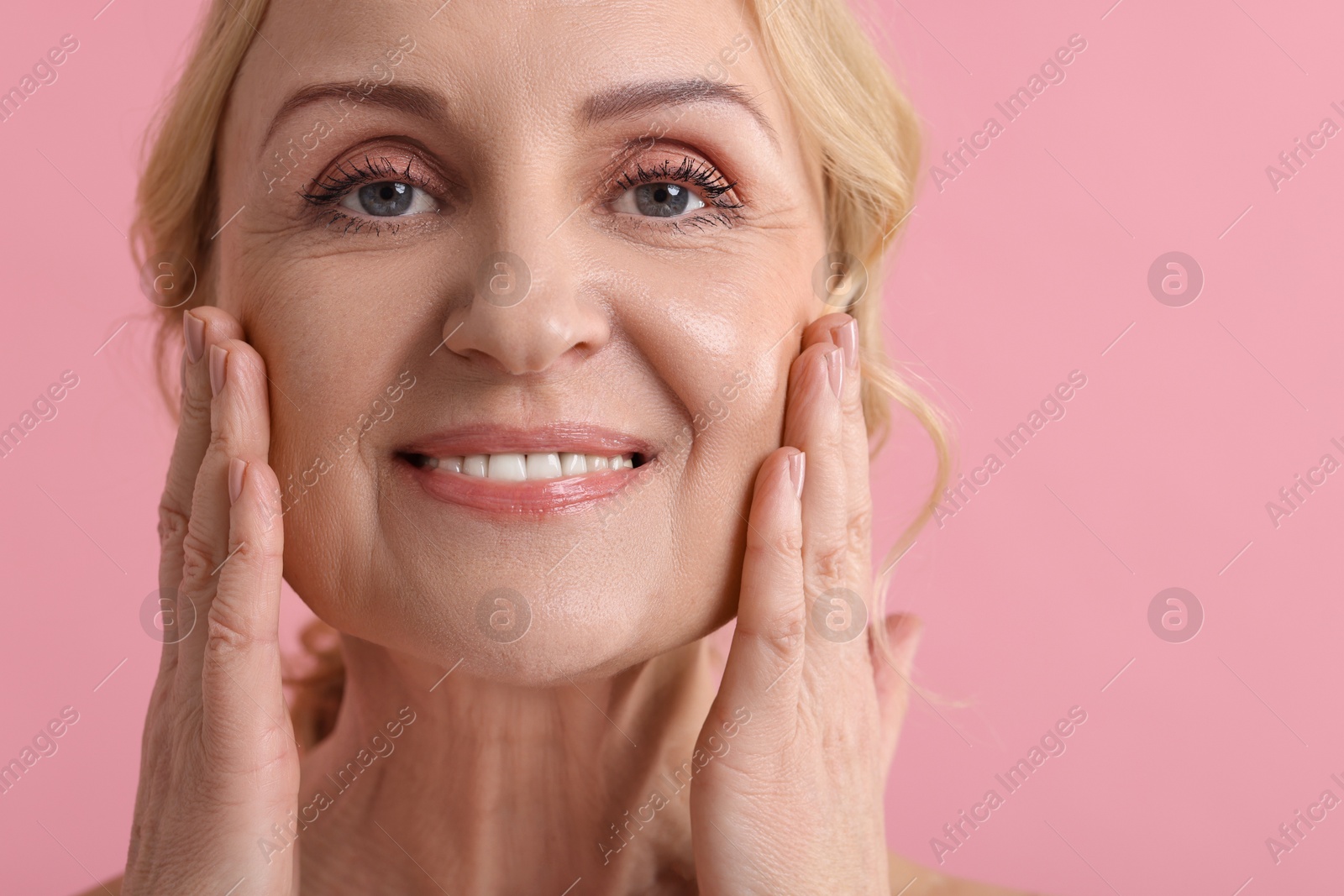 Photo of Smiling middle aged woman on pink background