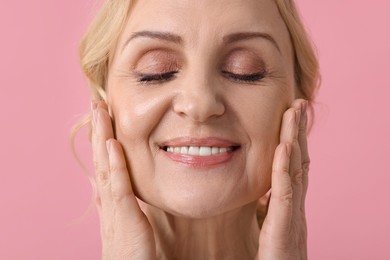 Photo of Smiling middle aged woman on pink background