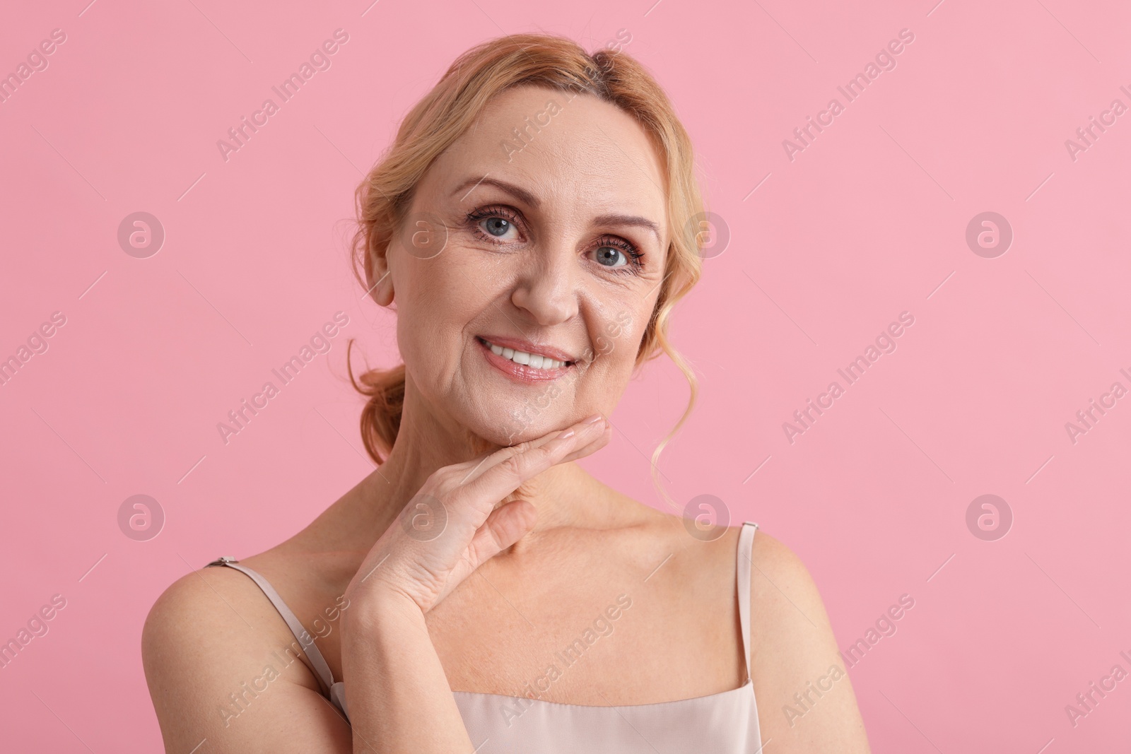 Photo of Smiling middle aged woman on pink background