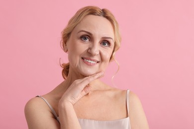 Photo of Smiling middle aged woman on pink background