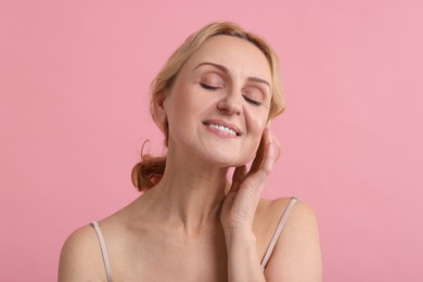 Photo of Smiling middle aged woman on pink background