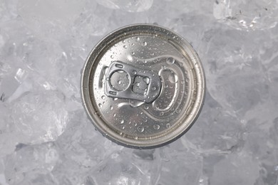 Photo of Refreshing drink in can on ice cubes, top view