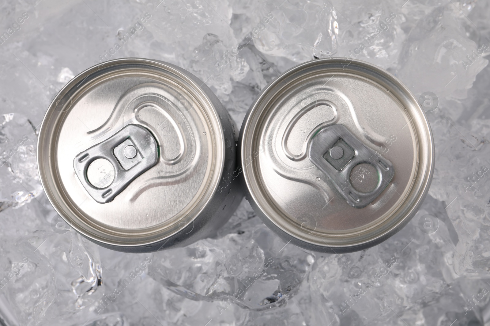 Refreshing drinks in cans on ice cubes, top view Photo of Refreshing drinks in cans on ice cubes, top view