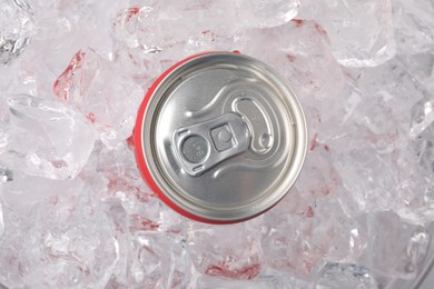 Photo of Refreshing drink in can on ice cubes, top view