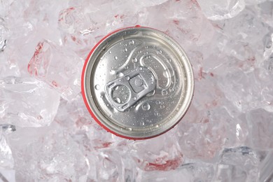 Photo of Refreshing drink in can on ice cubes, top view