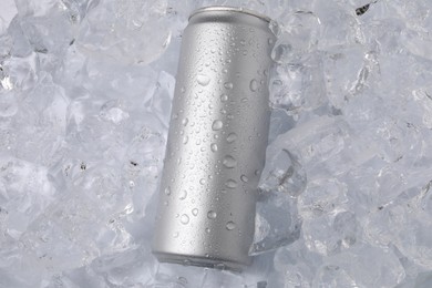 Photo of Refreshing drink in can on ice cubes, top view
