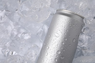 Photo of Refreshing drink in can on ice cubes, top view