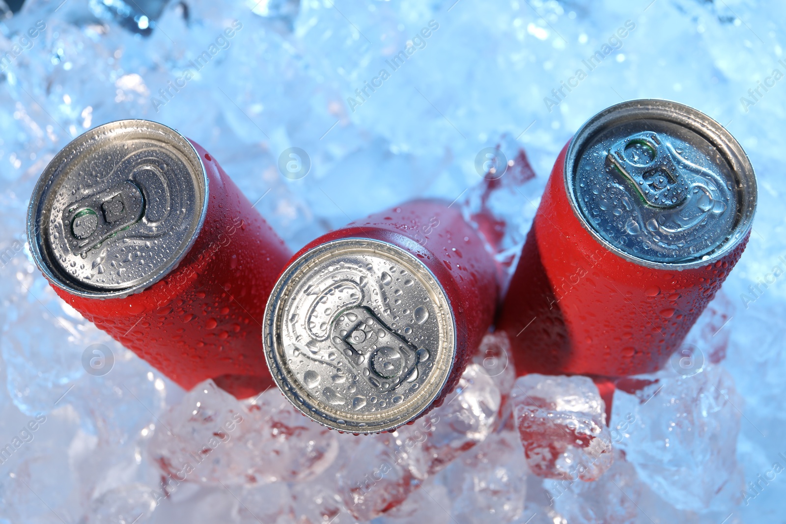 Refreshing drinks in cans on ice cubes, closeup Photo of Refreshing drinks in cans on ice cubes, closeup