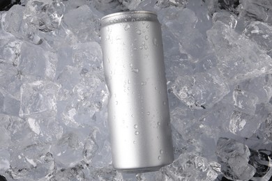 Photo of Refreshing drink in can on ice cubes, top view