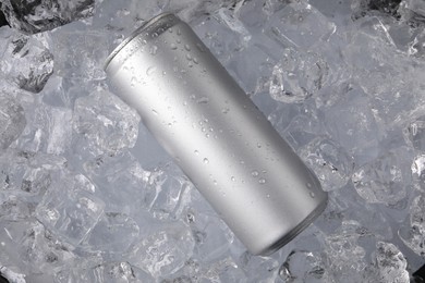 Photo of Refreshing drink in can on ice cubes, top view