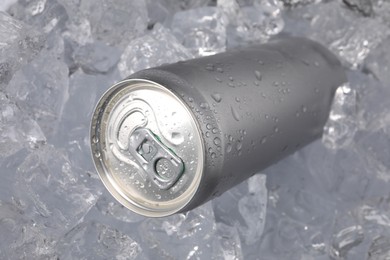 Photo of Refreshing drink in can on ice cubes, closeup