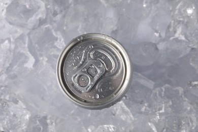 Photo of Refreshing drink in can on ice cubes, top view