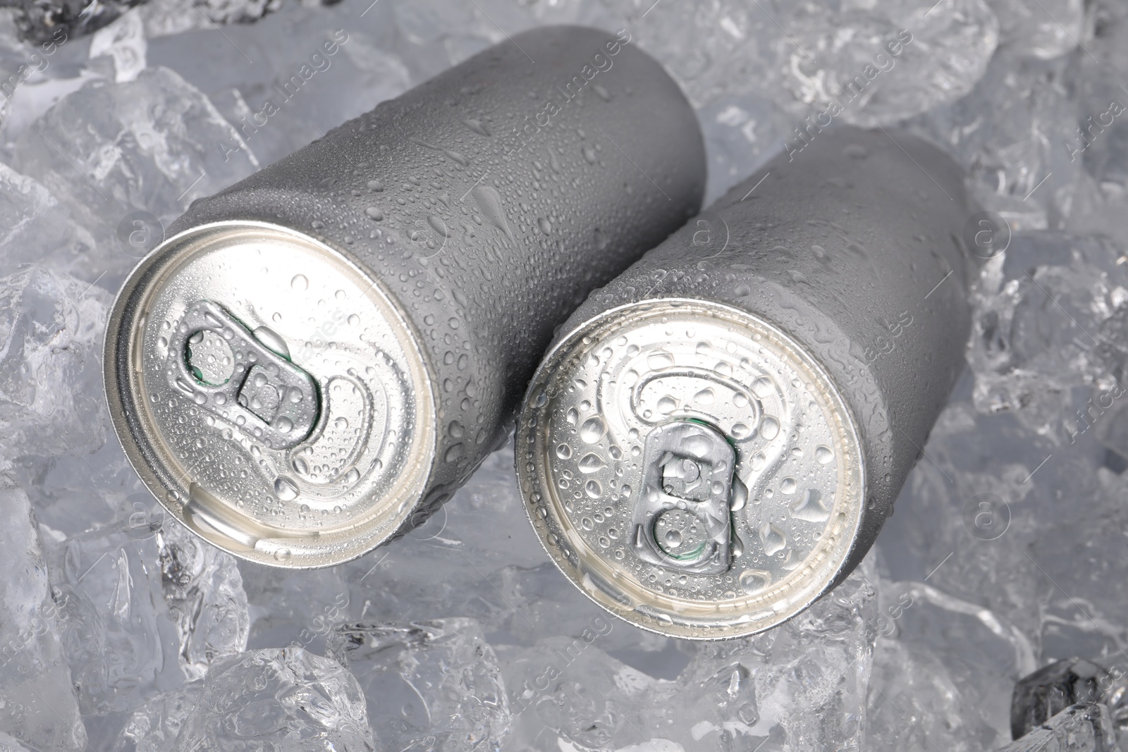 Refreshing drinks in cans on ice cubes, closeup Photo of Refreshing drinks in cans on ice cubes, closeup