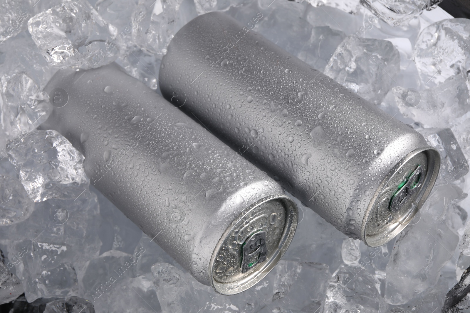 Refreshing drinks in cans on ice cubes, closeup Photo of Refreshing drinks in cans on ice cubes, closeup