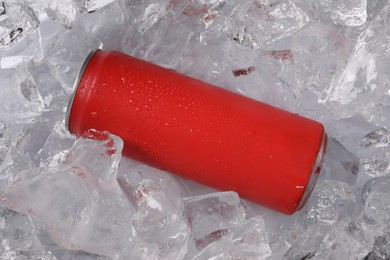 Photo of Refreshing drink in can on ice cubes, top view
