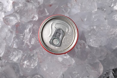 Photo of Refreshing drink in can on ice cubes, top view