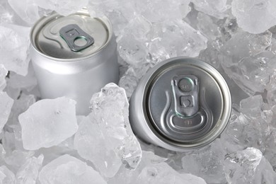 Photo of Cans of refreshing drink in ice cubes, above view