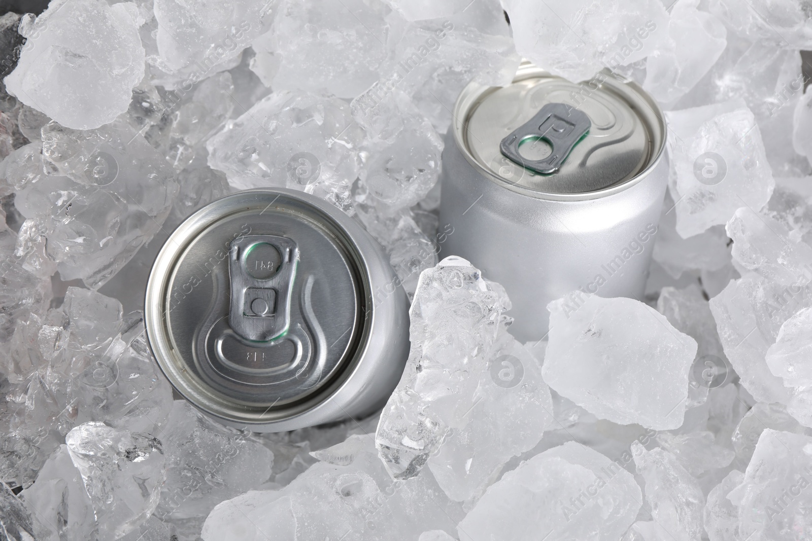 Cans of refreshing drink in ice cubes, above view Photo of Cans of refreshing drink in ice cubes, above view