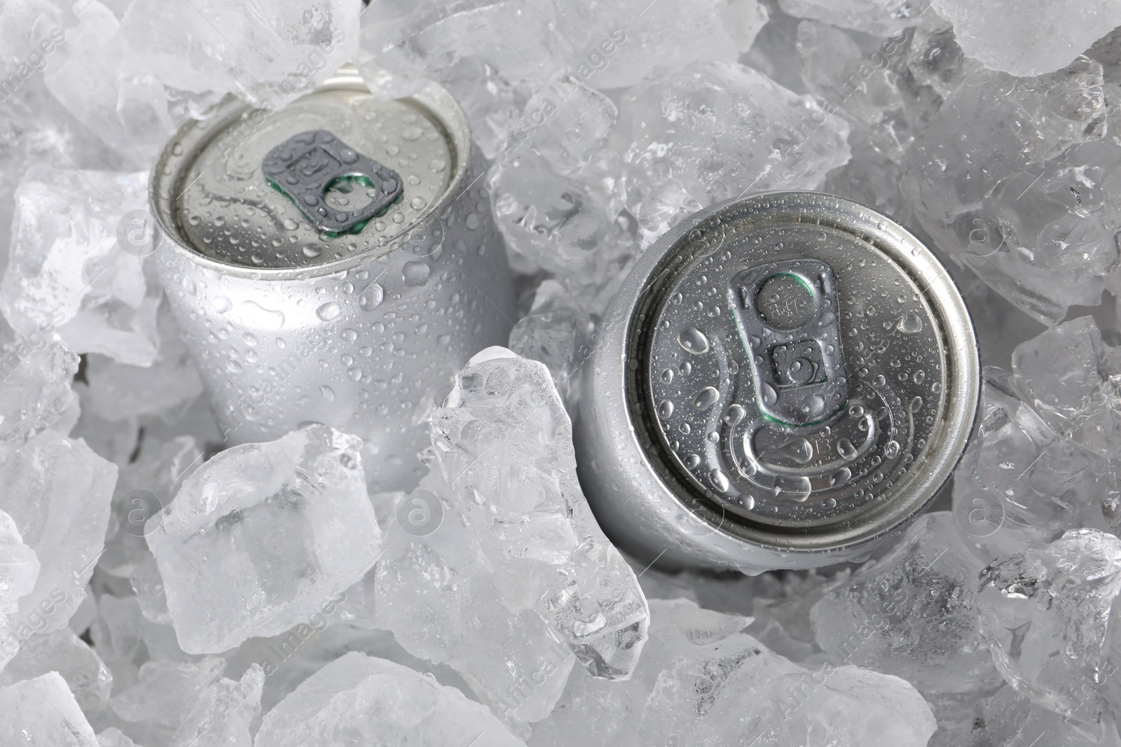 Cans of refreshing drink in ice cubes, above view Photo of Cans of refreshing drink in ice cubes, above view