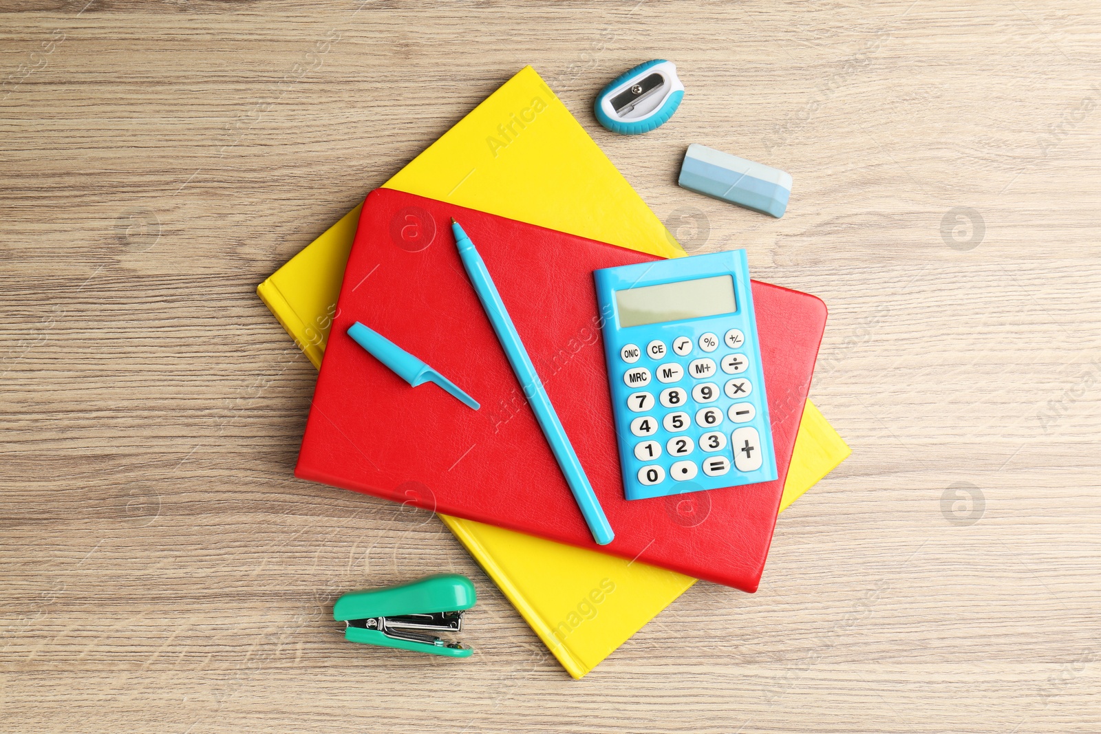 Photo of Doing homework. Notebooks and other different stationery on wooden table, flat lay