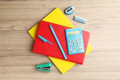 Photo of Doing homework. Notebooks and other different stationery on wooden table, flat lay