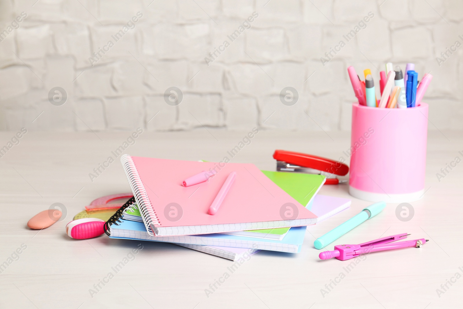 Photo of Doing homework. Notebooks and other different stationery on wooden table, closeup