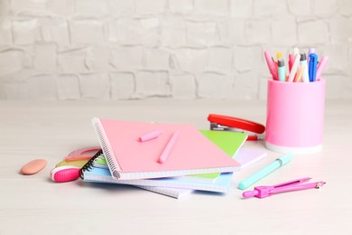 Photo of Doing homework. Notebooks and other different stationery on wooden table, closeup