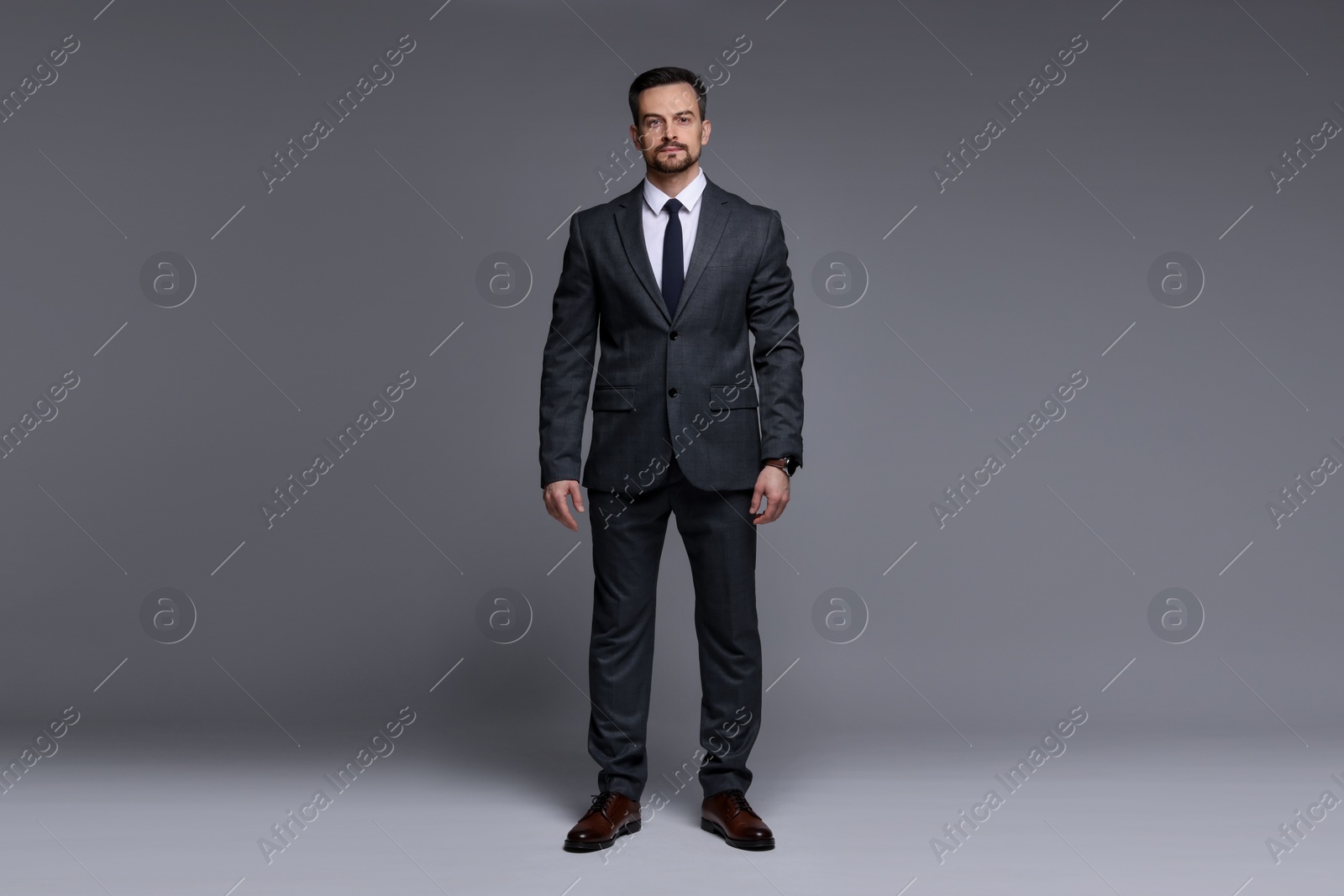 Photo of Confident man in classic suit on grey background