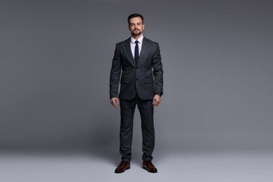 Photo of Confident man in classic suit on grey background