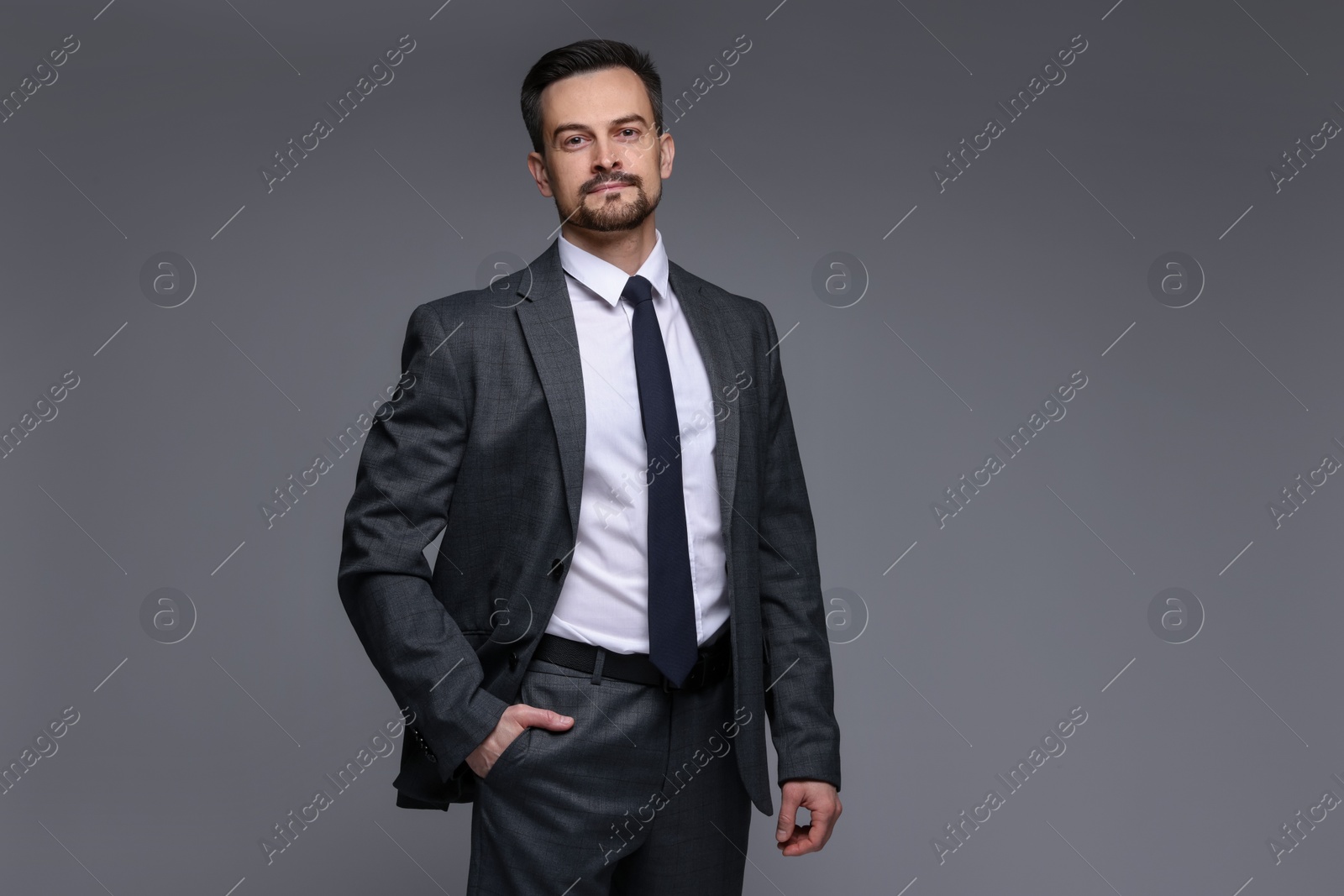 Photo of Confident man in classic suit on grey background