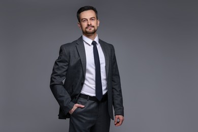 Confident man in classic suit on grey background