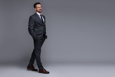 Photo of Handsome man in classic suit on grey background. Space for text