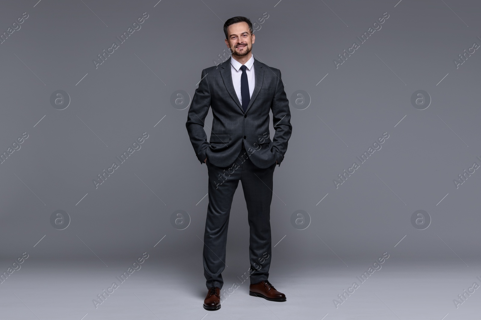 Photo of Handsome man in classic suit on grey background