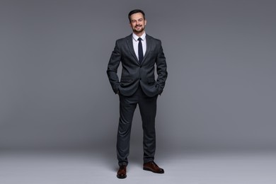 Photo of Handsome man in classic suit on grey background