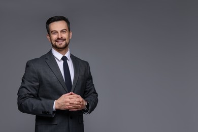 Photo of Handsome man in classic suit on grey background. Space for text