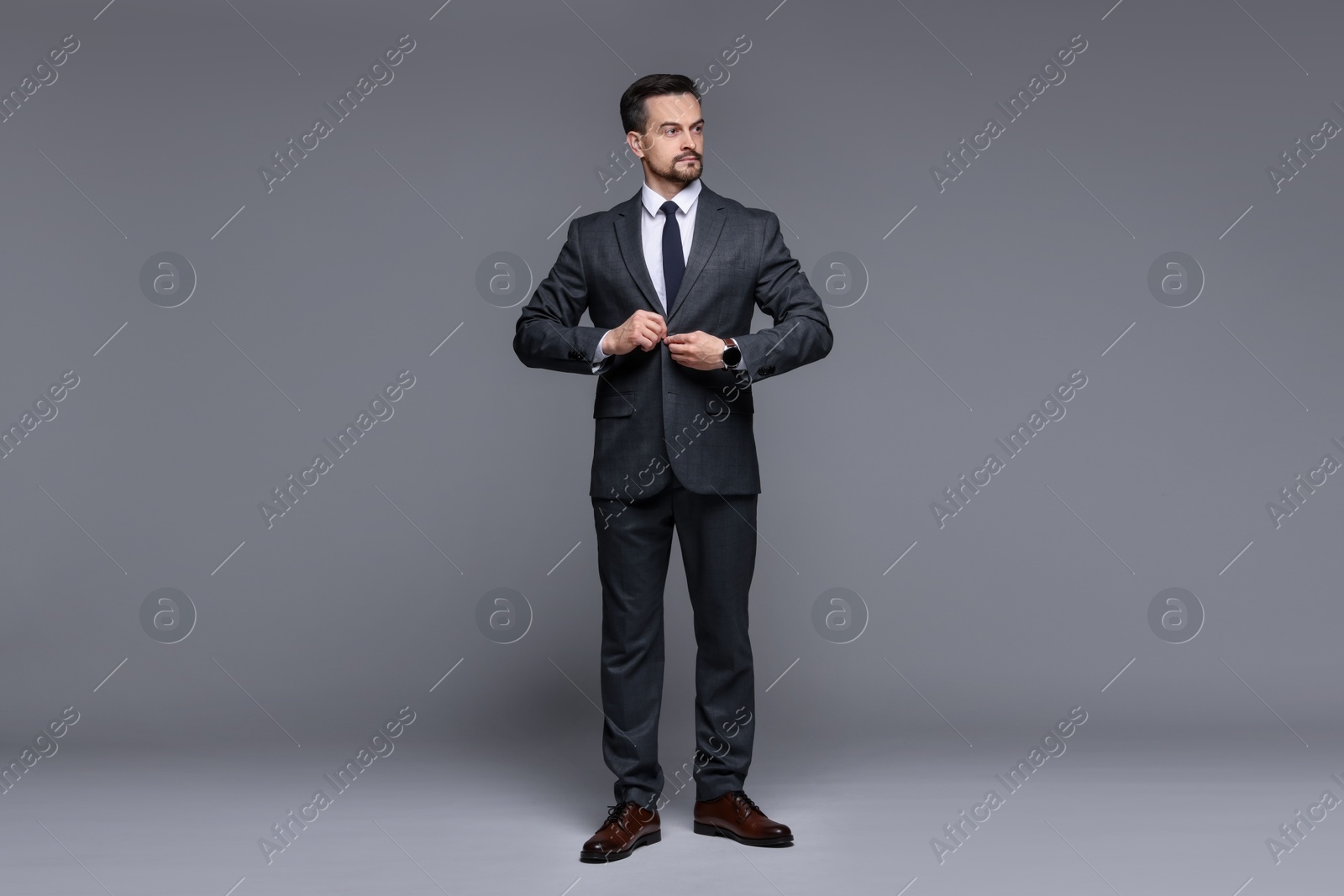 Photo of Confident man in classic suit on grey background