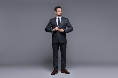 Photo of Confident man in classic suit on grey background