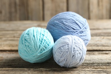 Balls of colorful yarn on wooden table, closeup