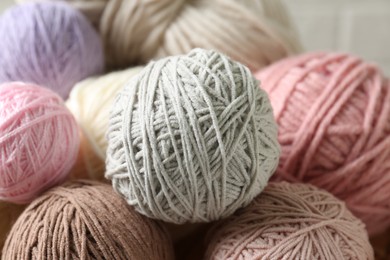 Many balls of colorful yarn on table, closeup