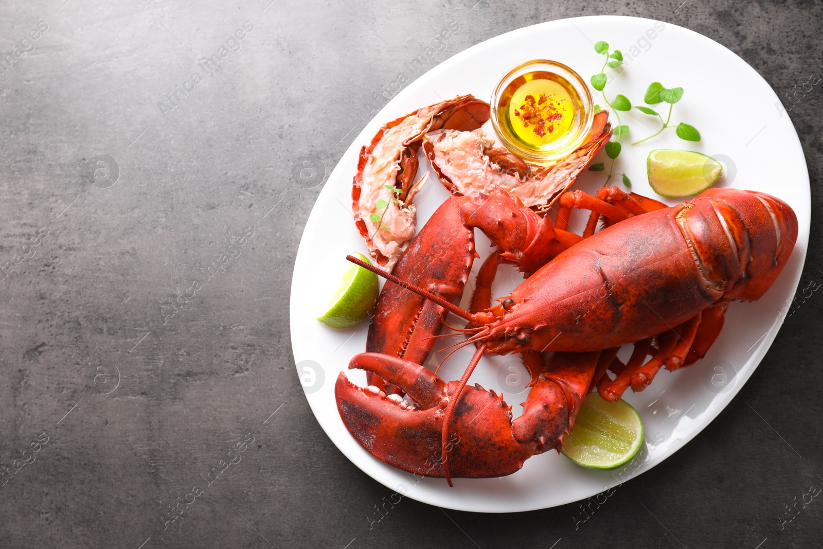 Photo of Delicious boiled lobster served on grey table, top view. Space for text