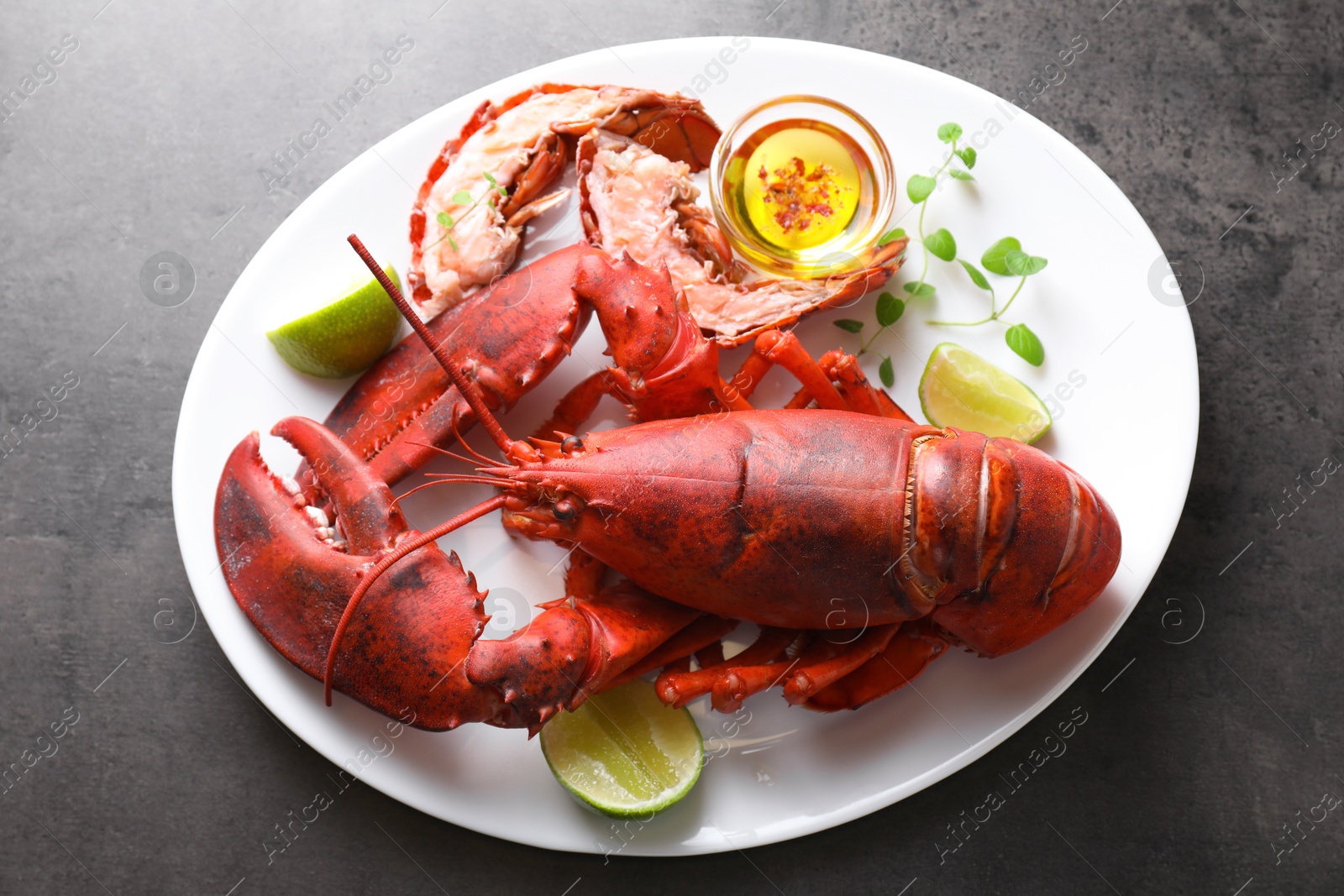 Photo of Delicious boiled lobster served on grey table, top view