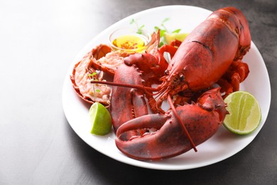 Photo of Delicious boiled lobster served on grey table, closeup