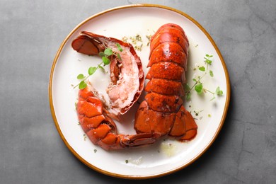 Photo of Delicious tails of boiled lobsters served on grey table, top view